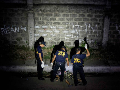 This picture taken on January 5, 2017, shows policemen investigating a crime scene where a woman was shot dead by unidentified gunmen in Manila. People going to mass at one of the most famous churches in the Philippine capital over Christmas were met by a disturbing sight: poster-size pictures of …