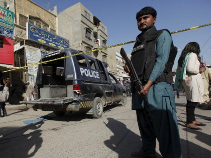 A policeman guards a police vehicle after it was attacked by Taliban gunmen while policeme