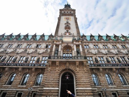 A woman points at Hamburg's town hall (Rathaus), the seat of the city state's lo