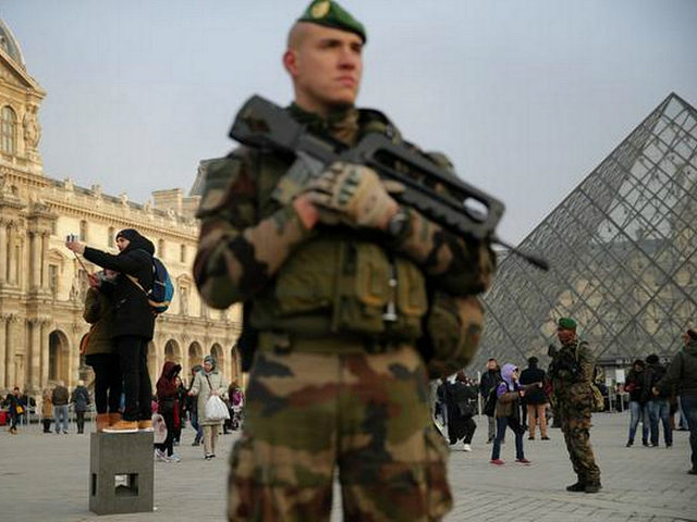A soldier stands guard outside the Louvre museum, in Paris, Friday, Dec. 30, 2016. With a