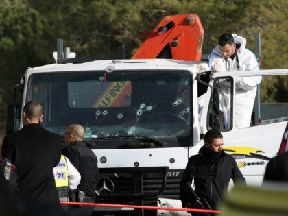 An Israeli forensics expert gathers evidence as security forces and emergency personnel ga