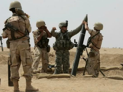 A US military adviser helps soldiers from the 17th Iraqi army brigade load a mortar during a live fire drill in Mahmudiyah, south of Baghdad, on April 06, 2009. A series of car bombings in Baghdad killed at least 32 people and wounded 129 others, security officials said. AFP PHOTO …