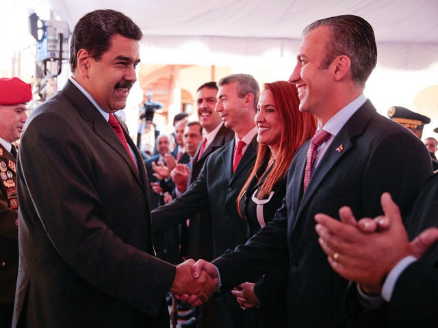 Venezuela's President Nicolas Maduro (C) shakes hands with Venezuela's new Vice-President