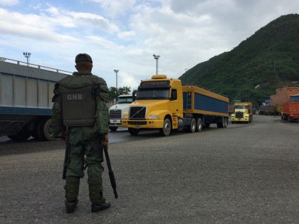 In this Dec. 19, 2016 photo, a National Guard soldier watches over cargo trucks leaving th