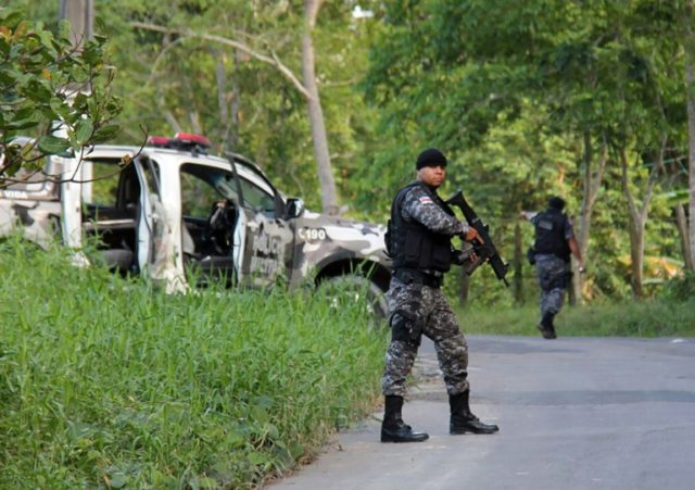 Military police officers track fugitives of the Anisio Jobim Penitentiary Complex after a