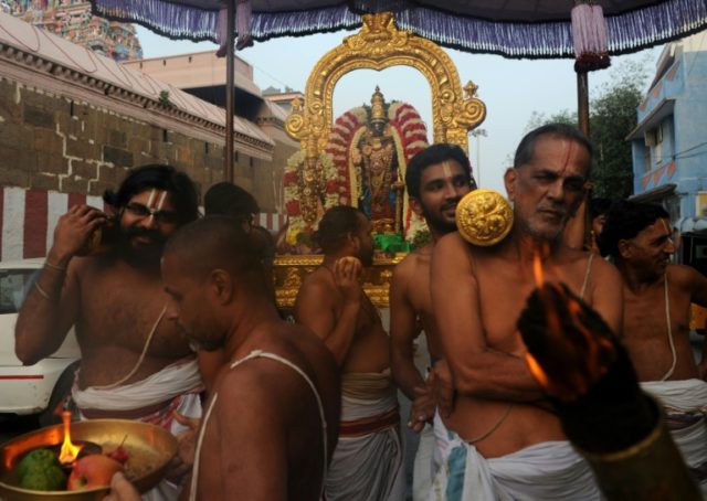 Indian temple priests carry an idol of Hindu god Parthasarathy in Chennai, capital of Tami