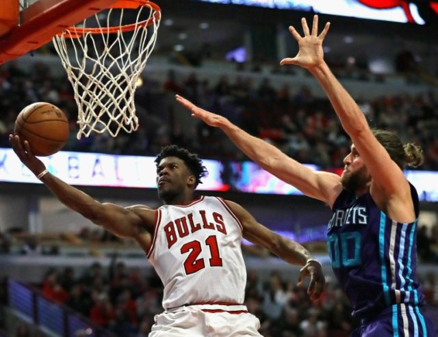 Jimmy Butler of the Chicago Bulls puts up a shot past Spencer Hawes of the Charlotte Horne