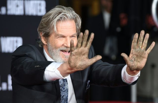 Actor Jeff Bridges displays his hands after imprinting them in a block of cement at a Hand