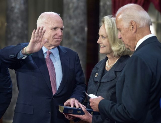 US Senator John McCain is sworn in by Vice-President Joe Biden as Cindy McCain holds the B