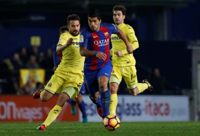 Villarreal's defender Mario (L) clashes with Barcelona's forward Luis Suarez on January 8,