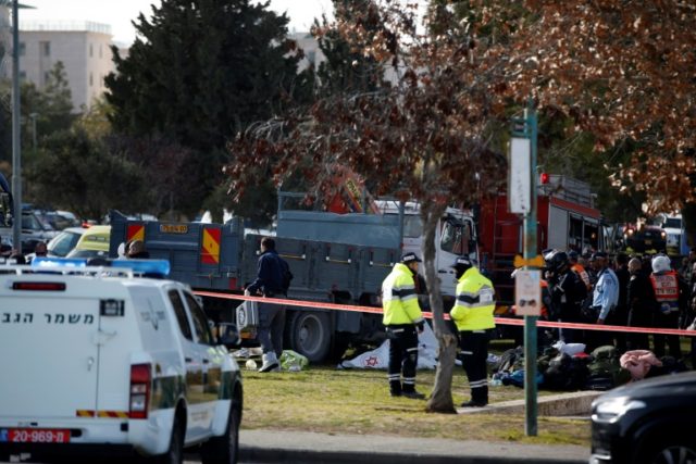 Israeli security forces and medics gather next to a flatbed truck at the site of a ramming