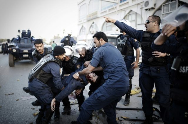 Bahraini police help an injured comrade after a bomb exploded during clashes between prote