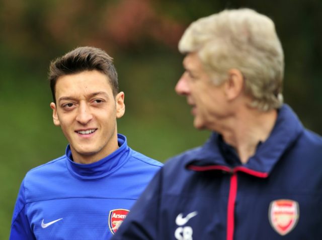 Mesut Ozil (left) talks to Arsene Wenger after joining Arsenal from Real Madrid in Septemb