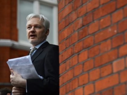 WikiLeaks founder Julian Assange addressing the media and holding a printed report of the