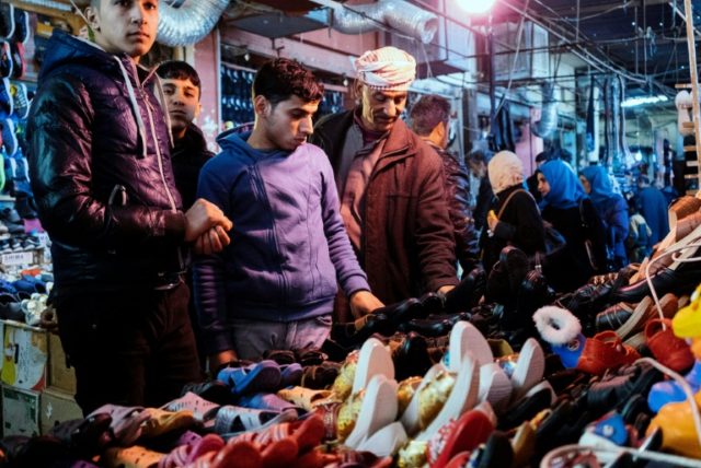 Iraqi men visit the great bazaar of Al-Zahraa in eastern Mosul on January 11, 2017, as the