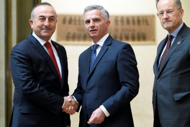 Turkey's Foreign Minister Mevlut Cavusoglu (L) shakes hands with Swiss sounterpart Didier