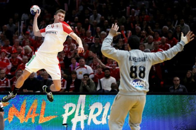 Denmark's left wing Magnus Landin Jacobsen (L) jumps to shoot and score during the 25th IH