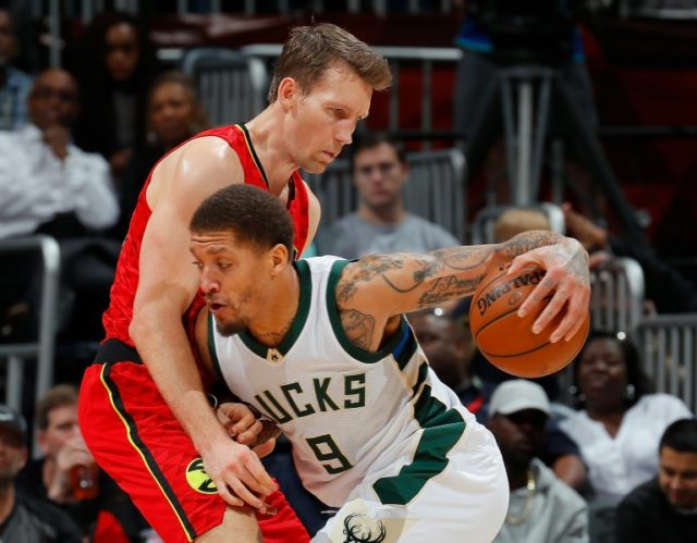 Michael Beasley (R) of the Milwaukee Bucks drives against Mike Dunleavy of the Atlanta Haw