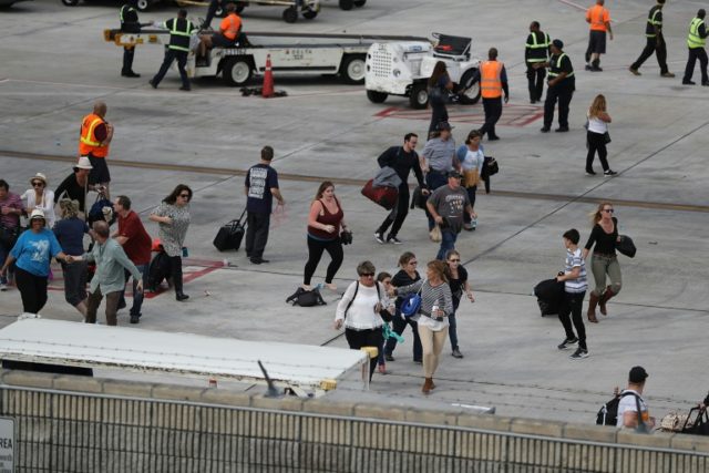 People seek cover on the tarmac of Fort Lauderdale-Hollywood International airport after a