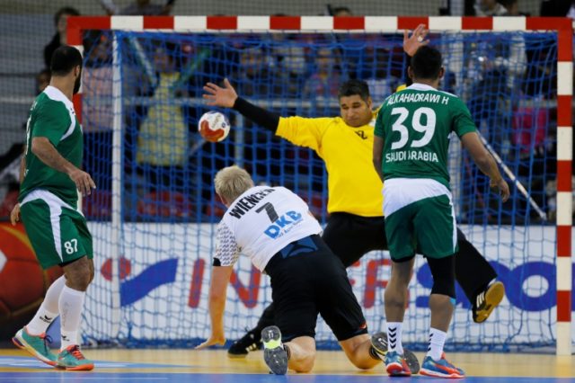 Germany's pivot Patrick Wiencek (Bottom) shoots against Saudi Arabia's goalkeeper Manaf Al