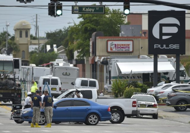 Police and investigators work near the area of the mass shooting at the Pulse nightclub on