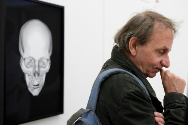 Controversial, award-winning French author Michel Houellebecq stands next to his x-rayed s