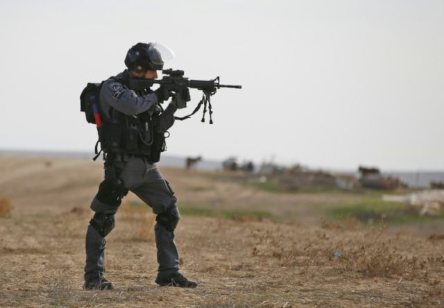Israeli policeman takes aim in the Bedouin village of Umm al-Heiran, in the Negev desert,