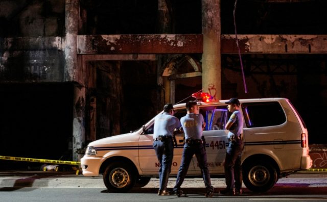 Police officers photographed at a crime scene in Manila on December 23, 2016