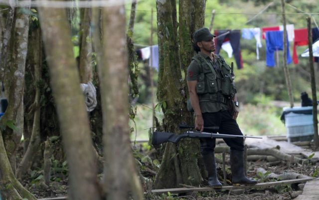 FARC guerrilla fighters stand at the Front 34 Alberto Martinez encampment in Vegaez munici