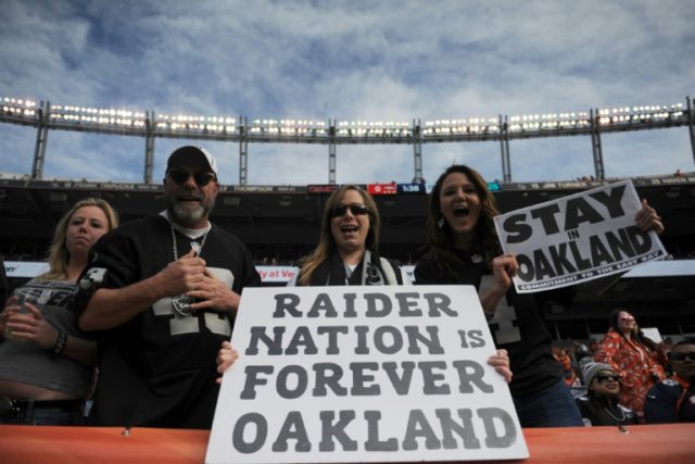Oakland Raiders fans hold signs before the game against the Denver Broncos at Sports Autho
