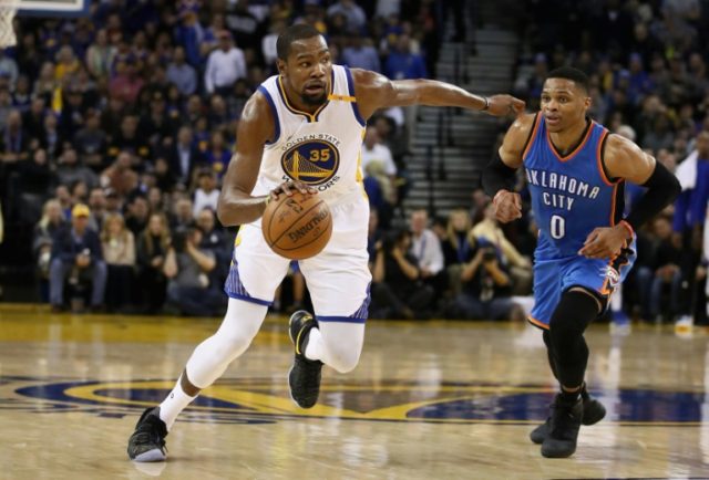Kevin Durant of the Golden State Warriors dribbles past Russell Westbrook of the Oklahoma