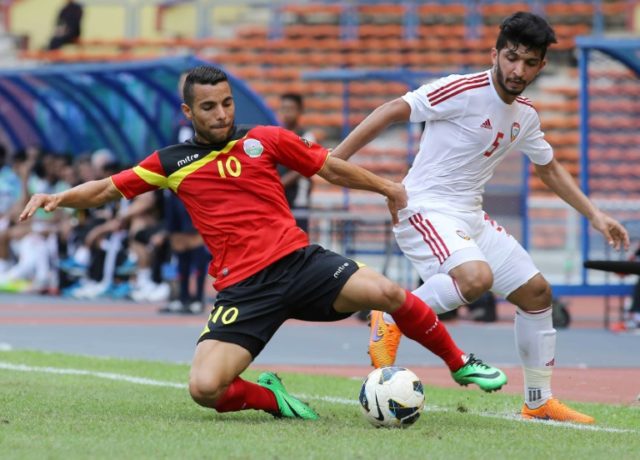 Rodrigo Sousa of East Timor (L) and Amer Abdulrahman of UAE (R) fight for the ball during