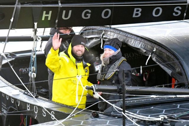 Second-placed British skipper Alex Thomson (left) celebrates aboard his Imoca monohull Hug