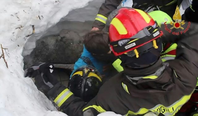 Picture released by Italy's Vigili del Fuoco fire service shows a child (C) being rescued