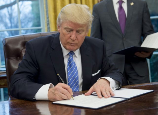 US President Donald Trump signs an executive order withdrawing the US from the Trans-Pacif