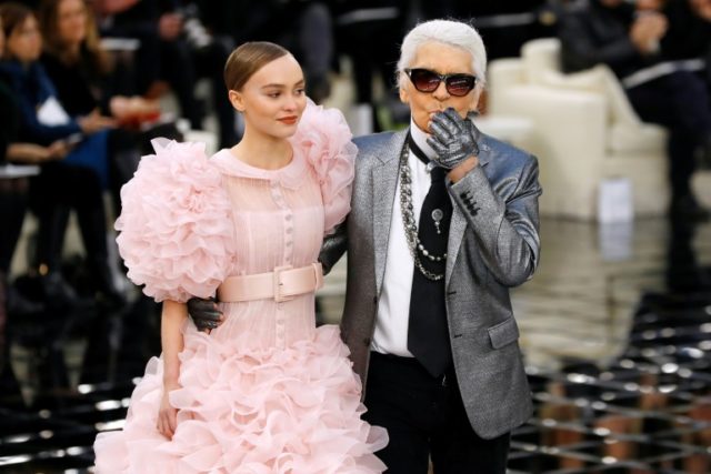 German fashion designer Karl Lagerfeld (R) salutes the audience with actress Lily-Rose Dep