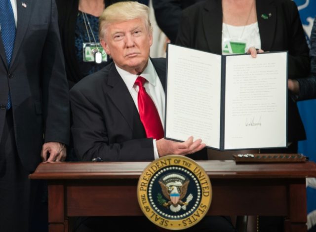 US President Donald Trump signs an executive order to start the Mexico border wall project at the Department of Homeland Security facility in Washington DC, on January 25, 2017