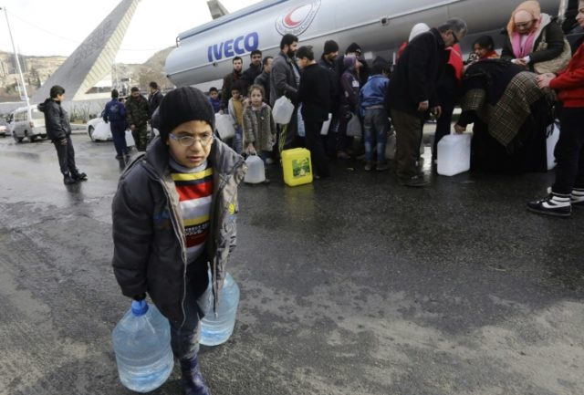 Syrians wait to fill plastic containers with water provided by the Syrian Arab Red Crescen