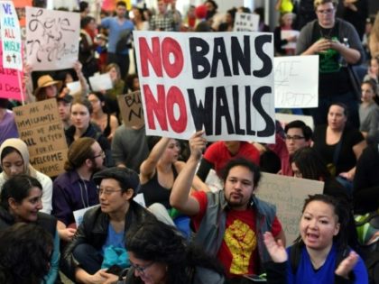 Protesters sit in the international terminal at San Francisco International Airport in Cal