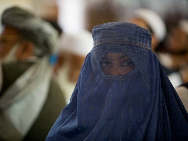 An Afghan women covered with a burqa listens to the former Taliban commander and presidential candidate Mullah Abdul Salam Rocketi's speech, during a campaign rally in Kabul, Afghanistan, Friday, Aug. 14, 2009. Afghans will head to the polls on Aug. 20 to elect a new president. (AP Photo/Farzana Wahidy)