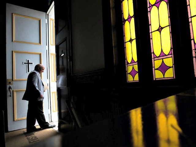 A parishioner at First Baptist Church, a predominantly African-American congregation, leaves after a worship service in Macon, Ga., on Sunday, July 10, 2016. There are two First Baptist Churches in Macon _ one black and one white. (AP Photo/Branden Camp)