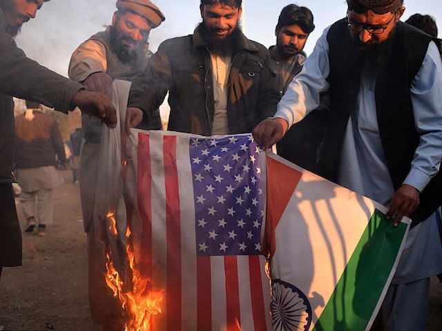 Pakistani supporters of the Jamaat-ud-Dawa (JuD) organisation burn Indian (R) and US flags
