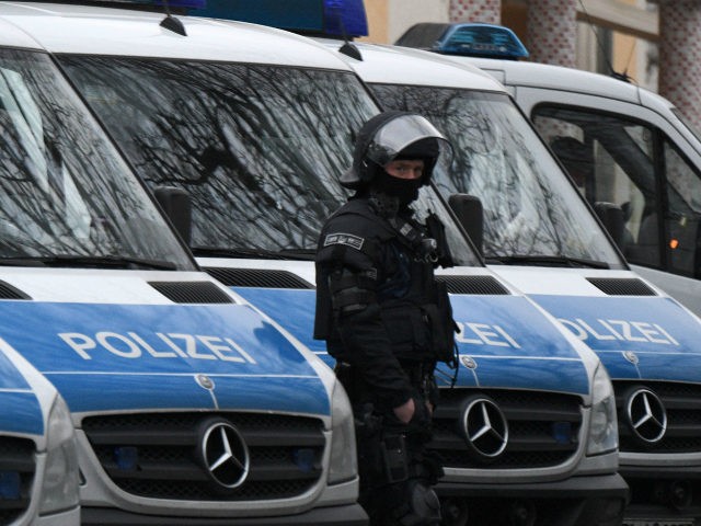 A policeman of a special unit stands next to police cars on the grounds of the Bilal mosqu