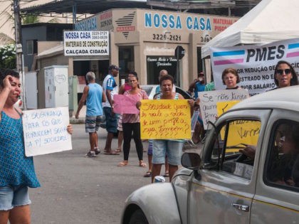 Relatives of military police show signs during a protest in support of a police strike at