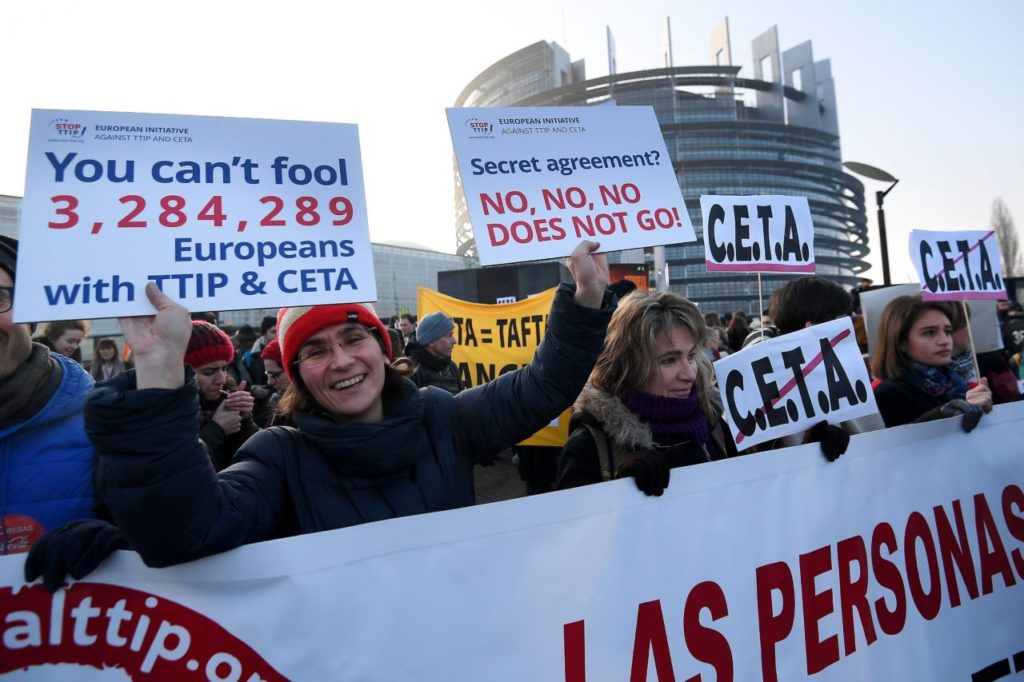 Protestors hold up placards reading 'You can't fool 3 284 289 European with TTIP and CETA' and 'Secret agreement - no, no, no does not go' as they demonstrate against the Transatlantic Trade and Investment Partnership (TTIP) and EU-Canada Comprehensive Economic and Trade Agreement (CETA) in front of the European Parliament in Strasbourg, eastern France, on February 15, 2017. / AFP / FREDERICK FLORIN (Photo credit should read FREDERICK FLORIN/AFP/Getty Images)