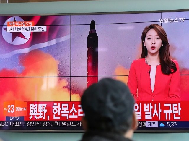 A man watches a TV news program reporting about North Korea's missile at the Seoul Tr