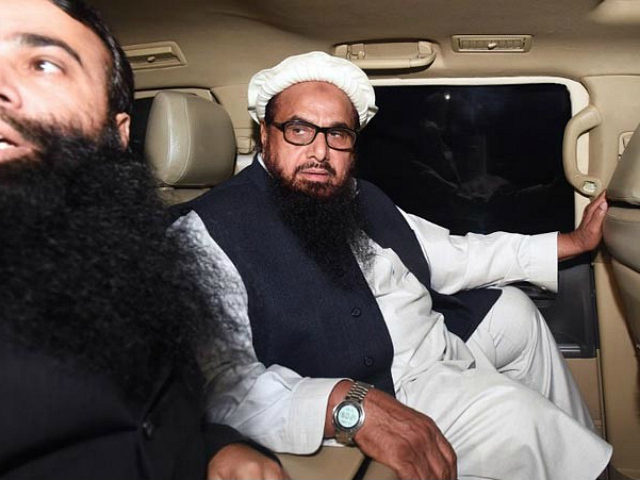 Pakistani leader of the Jamaat-ud-Dawa (JuD) organisation Hafiz Saeed (R) leaves in a car