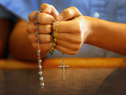 Catholic rosary beads in hand