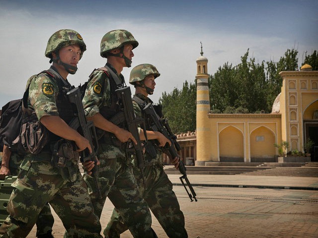 KASHGAR, CHINA - JULY 31: Chinese soldiers march in front of the Id Kah Mosque, China's largest, on July 31, 2014 in Kashgar, China. China has increased security in many parts of the restive Xinjiang Uyghur Autonomous Region following some of the worst violence in months in the Uyghur dominated …