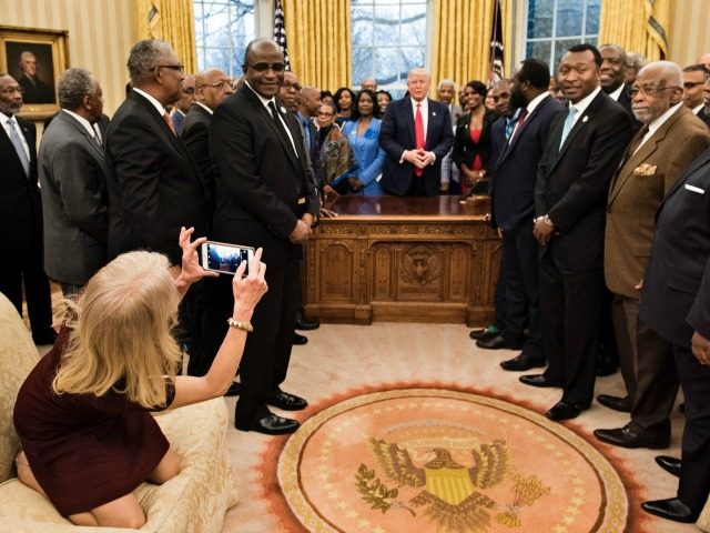 Counselor to the President Kellyanne Conway takes a photo as US President Donald Trump and